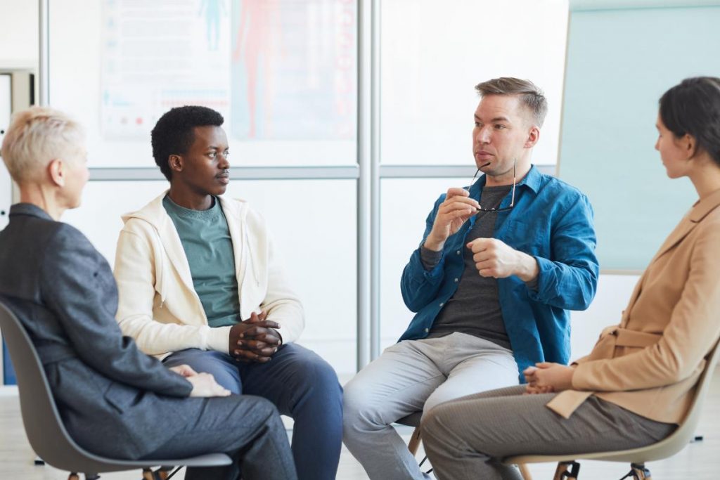a group of men discuss dbt and addiction treatment